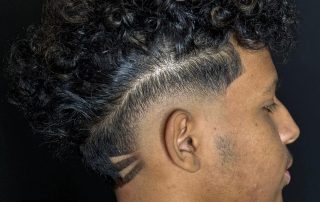 Curly top with a skin fade and shaved line detail