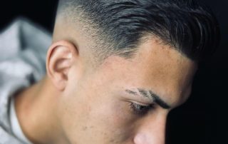 Slicked-back haircut with a tapered finish